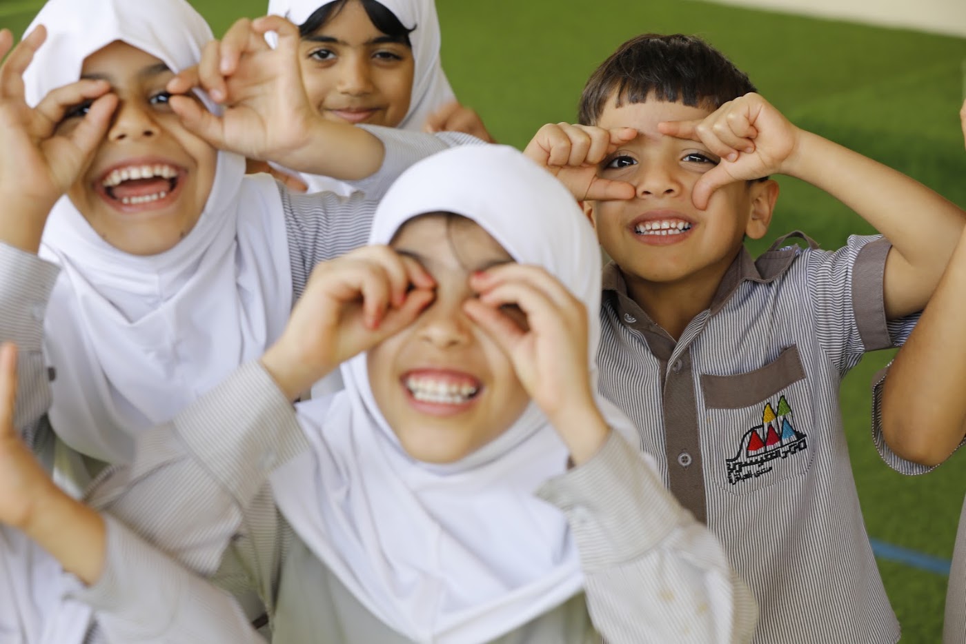 أطفال يضحكون ويصنعون نظارات بأيديهم